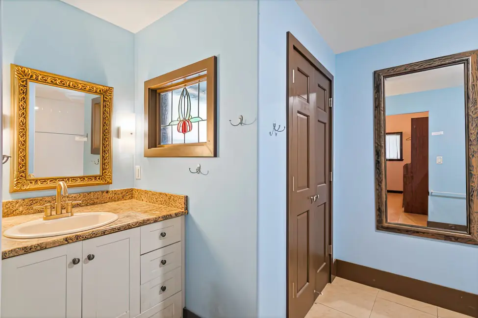 View of blue bathroom door and vanity